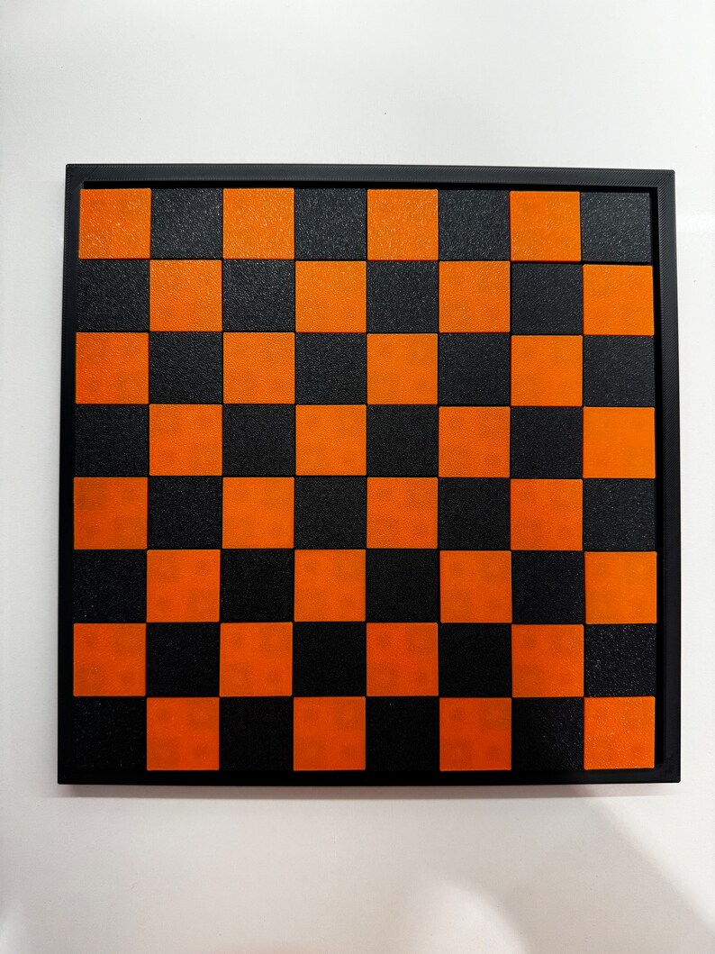 May include: A black and orange checkerboard with a black frame.