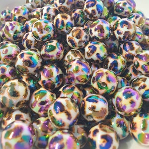 May include: A collection of iridescent white beads with a brown leopard print design. The beads have a glossy finish and are perfect for crafting jewellery.