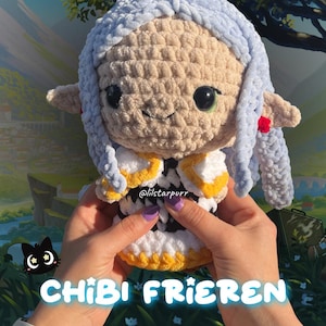 Puede incluir: Muñeca de ganchillo hecha a mano de un personaje con cabello azul claro y un atuendo blanco y amarillo. La muñeca tiene ojos verdes grandes y la sostiene una persona. El texto "crochet pattern RELEASE" y "CHIBI FRIEREN" son visibles.