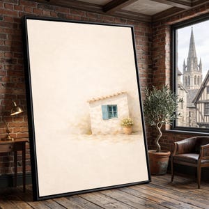May include: A framed art print depicts a quaint white building with a blue window and a small tiled roof. A terracotta pot with flowers sits beside the building. The artwork is set against a neutral background, with a black frame.