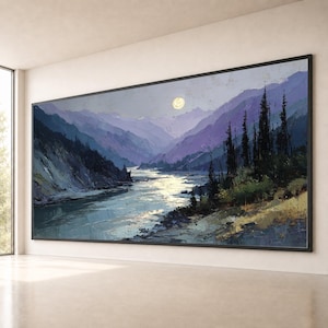 May include: A large rectangular landscape painting in a black frame featuring a river flowing through a valley of purple mountains under a pale yellow moon. Dark evergreen trees line the riverbank, with textured brushstrokes depicting the water reflecting light and the rugged terrain of the mountain slopes.