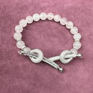 Può includere: Un braccialetto di pietre bianche con una chiusura a nodo in argento. Il braccialetto è fatto di perline rotonde e ha un aspetto delicato e femminile.