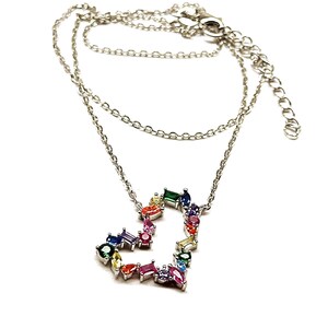 May include: A silver chain necklace with a heart-shaped pendant made of colorful gemstones. The pendant is made of small, multi-colored stones set in silver.