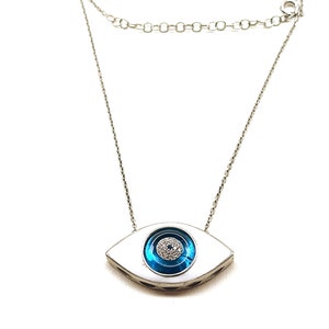 May include: Silver necklace with a blue evil eye pendant. The pendant is surrounded by small white stones.