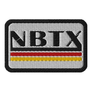 Könnte beinhalten: Ein gestickter schwarzer und weißer Aufnäher mit dem Text "NBTX" in schwarzen Buchstaben. Der Aufnäher hat einen roten und gelben Streifen am unteren Rand.