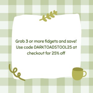 May include: A white, rounded rectangle with text and decorative elements against a green and white checkered background. The text reads, "Grab 3 or more fidgets and save! Use code DARKTOADSTOOL25 at checkout for 25% off."