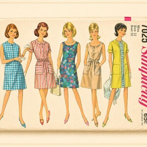 Op de afbeelding: Een vintage Simplicity naaipatroon envelop 7025 voor maat 12, buste 32. De illustratie toont vijf variaties van een mouwloze of kortmouwige jurk met zakken, waaronder blauw gingham, rode strepen, bloemenprint en effen kleuren.