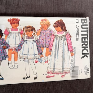 Op de afbeelding: Butterick Classics naaipatroon met illustraties van meisjes in jurken. Het patroon bevat maten 4-5-6. De omslag toont verschillende jurk ontwerpen met bloemen en effen stoffen, en het Butterick logo.