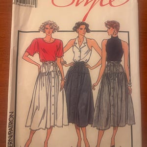 May include: Vintage sewing pattern titled "Style" featuring illustrations of three different skirt and top outfits. The pattern includes a red top and white skirt, a white top and navy skirt, and a black top and striped skirt.
