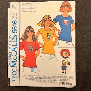 Può includere: Modello di cucito vintage McCall's 5616 per magliette da donna con trasferibili "Raggedy Ann" e "Raggedy Andy". Il modello mostra le magliette in rosso, giallo e blu, con una circonferenza del busto di 83 cm.