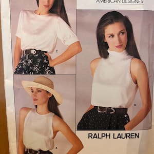 May include: Vogue Patterns American Designer sewing pattern featuring three different Ralph Lauren designs. The image shows a white top with short sleeves, a white sleeveless top, and a white turtleneck top. The pattern includes a skirt and a hat.
