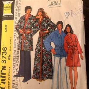 May include: Vintage McCall's 3738 sewing pattern for robes. The pattern shows illustrations of robes in different styles, including a long patterned robe, a blue robe, and a red robe. The pattern is marked "Extra Carefree".