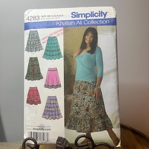以下が含まれることがあります： Khaliah AliコレクションのSimplicity縫製パターン4283。パターンは、長い柄のスカートを着用している女性を含む、いくつかのスカートのデザインを特徴としています。パターンのサイズはAA 10,12,14,16,18です。
