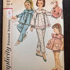 May include: Vintage Simplicity printed pattern for a girl's size 8. The cover art features illustrations of girls in pajamas, including a blue gingham set, a floral set, and a pink dress. The pattern number is 3690.