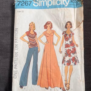 May include: Vintage Simplicity sewing pattern 7267, size 12. The pattern features illustrations of three different women's outfits: a striped top with flared jeans, a long peach dress, and a floral dress. The pattern is for stretch knits only.