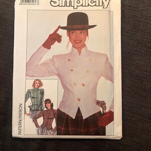 May include: Simplicity sewing pattern showing a woman in a white jacket with gold buttons, a plaid skirt, and a hat. The pattern includes images of different outfit variations. The package is labelled "Simplicity" and includes size information.