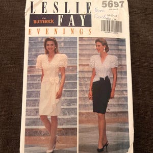 May include: A vintage sewing pattern for Leslie Fay Evening dresses. The pattern features two dress designs, one with a bow and the other with a pencil skirt. The pattern is for Butterick and includes the size 18-20-22.