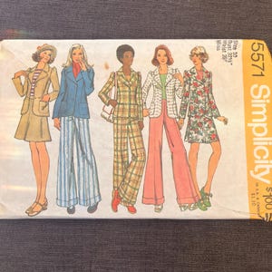 May include: A vintage Simplicity sewing pattern envelope, featuring illustrations of five women in 1970s-style outfits. The outfits include suits, jackets, and dresses in various colors and patterns. The envelope is labeled "5571" and includes size and price information.