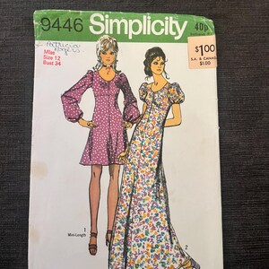 Peut inclure: Une pochette de patron de couture Simplicity 9446 illustrant deux modèles de robes. L'une est une robe courte violette à pois blancs avec des manches longues, et l'autre est une robe longue à motif floral avec des manches courtes bouffantes.