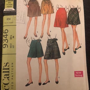 May include: A vintage McCall's sewing pattern for a skirt set in two lengths. The pattern shows illustrations of skirts in different colours and patterns, including brown, gold, red, and plaid. The pattern includes the text "New Sizing".