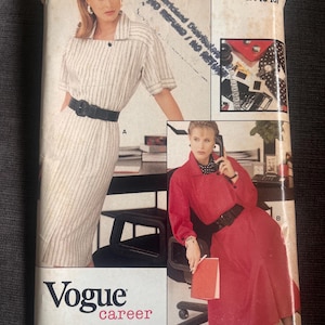 May include: Vogue Career sewing pattern featuring two dress designs. One dress is a striped, collared style with a black belt. The other is a red dress with a black belt. The pattern is rated easy and includes sizes 14-16-18.