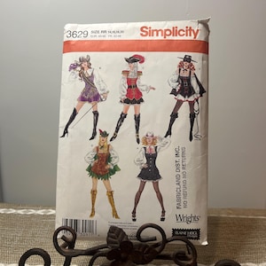 Könnte beinhalten: Simplicity Schnittmuster 3629 mit Illustrationen von sechs verschiedenen Kostümdesigns. Das Schnittmuster enthält die Größen 14, 16, 18 und 20. Die Verpackung ist weiß mit rotem und schwarzem Text und Bildern der Kostüme.