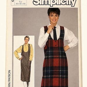 May include: A Simplicity sewing pattern envelope, number 6984, featuring sizes 12, 14, and 16. The cover displays a sleeveless, mid-length plaid jumper dress in red, navy, and white, worn over a white collared shirt with a dark tie.