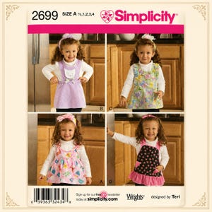 May include: Simplicity sewing pattern 2699 for children's pinafore dresses in sizes 1/2, 1, 2, 3, and 4. The pattern features four variations: a lavender cat-themed pinafore, a butterfly print pinafore, a pink floral pinafore, and a black floral pinafore.