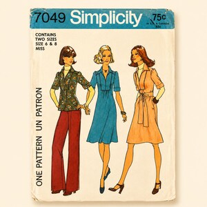 Peut inclure: Patron de couture Simplicity 7049 pour tailles 6 et 8. L'enveloppe présente des illustrations de trois tenues : une chemise à motif floral avec un pantalon rouge foncé, une robe bleue unie et une robe pêche unie, toutes à col et manches courtes.