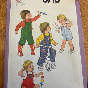 May include: Simplicity 8718 toddler pattern. The cover art features illustrations of children in various outfits, including overalls and a striped romper. The pattern includes the text "Pattern/Patron" and "Toddler Petit Enfant".