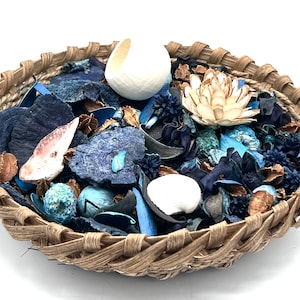 May include: A wicker basket filled with blue and brown potpourri, including dried flowers, leaves, and shells.