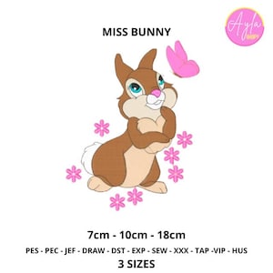 Può includere: Un disegno ricamato con Miss Bunny, un coniglio marrone con occhi blu e naso rosa, circondato da fiori rosa e una farfalla rosa. Il testo "MISS BUNNY" è sopra il coniglio. Disponibile in 3 misure: 7cm, 10cm e 18cm.