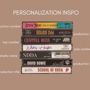 May include: A stack of cassette tapes with various artists and titles, including Stevie Nicks, Destiny's Child, Chappell Roan, Whitney Houston, and David Bowie. The bottom tape is labeled "School of Rock".