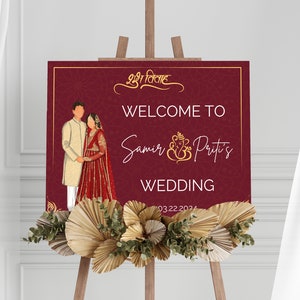 Puede incluir: Un cartel de bienvenida de boda de color burdeos con detalles dorados y un diseño floral. El cartel presenta una ilustración de dibujos animados de una pareja con atuendos tradicionales de boda india. El texto del cartel dice "Bienvenido a Samir & Priti's Wedding 03.22.2024".