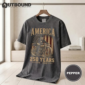 Dark t-shirt with "AMERICA 250 YEARS 1776 2026" and motorcycle graphic.