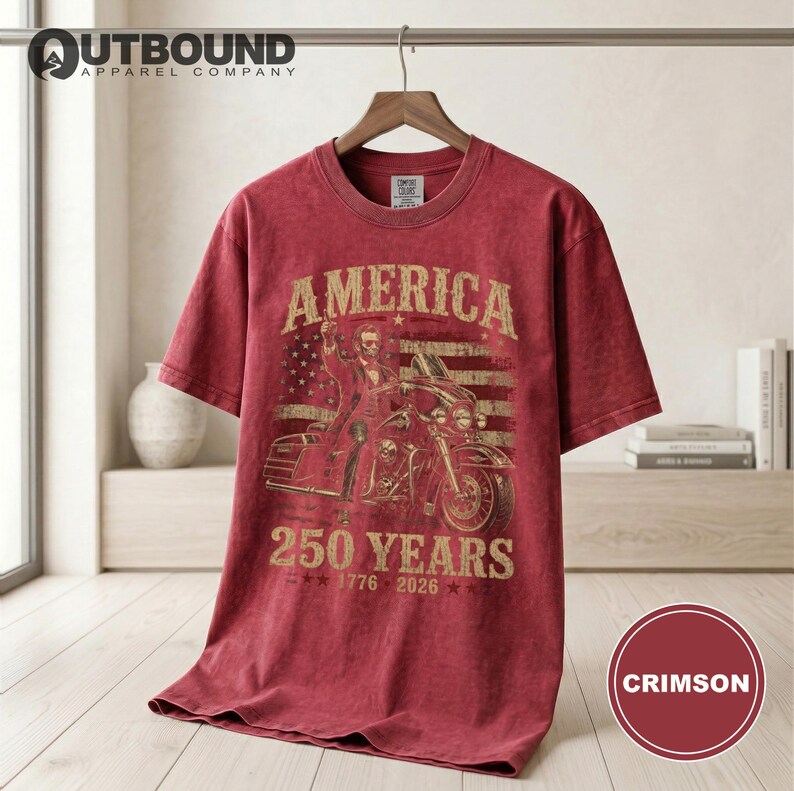 Red t-shirt with "America 250 Years 1776-2026" graphic and motorcycle rider.