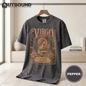 Dark grey t-shirt with mystical Virgo graphic, featuring a woman and text.