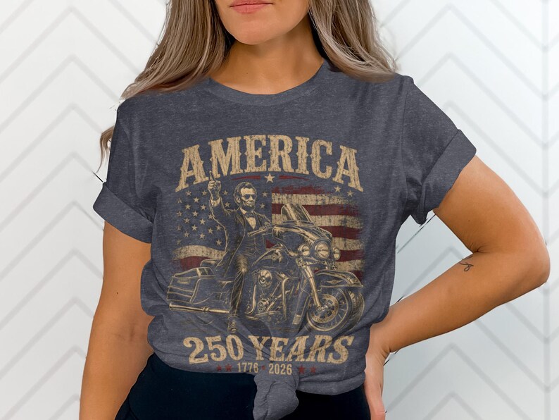 Abraham Lincoln riding a motorcycle with "America 250 Years 1776-2026" text.