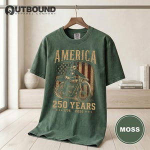 Green t-shirt with "America 250 Years 1776 2026" graphic.