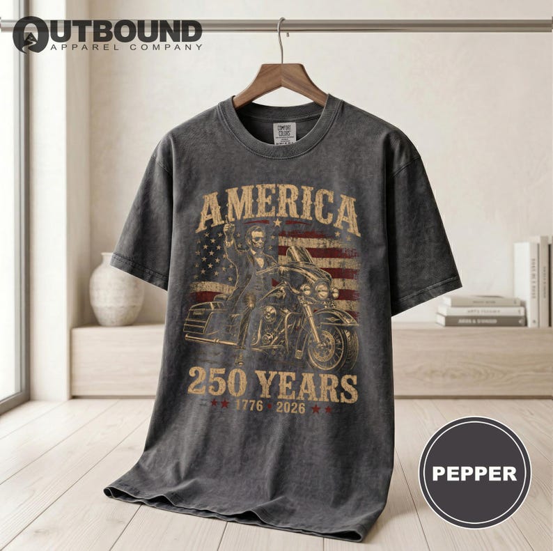 Dark grey t-shirt with "America 250 Years 1776 2026" and a motorcycle rider.