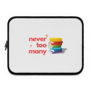 May include: White laptop sleeve with a black zipper and trim. The sleeve features the text "never too many" in red, with a star graphic. A stack of colorful books in yellow, orange, red, green, blue, and purple is also displayed.