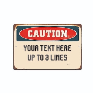 May include: A vintage-style metal sign with a red oval that says "CAUTION" in white letters. The sign has a distressed, rusty look and a cream-colored background. Below the oval, the text "YOUR TEXT HERE UP TO 3 LINES" is printed in black.