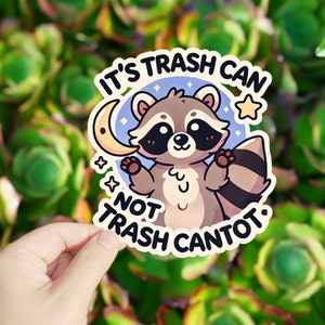 May include: A sticker with a cartoon raccoon holding a crescent moon and the text "It's trash can, not trash can't ot."