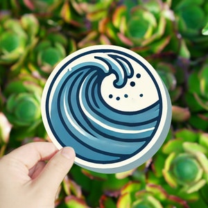 May include: A blue and white sticker with a stylized illustration of a wave breaking. The wave is drawn in a simple, cartoon style.