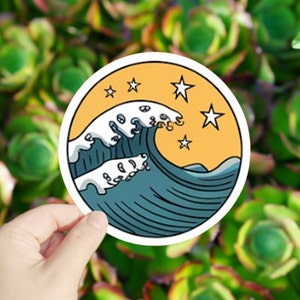 May include: A round sticker with a blue and white wave design on a yellow background with white stars.
