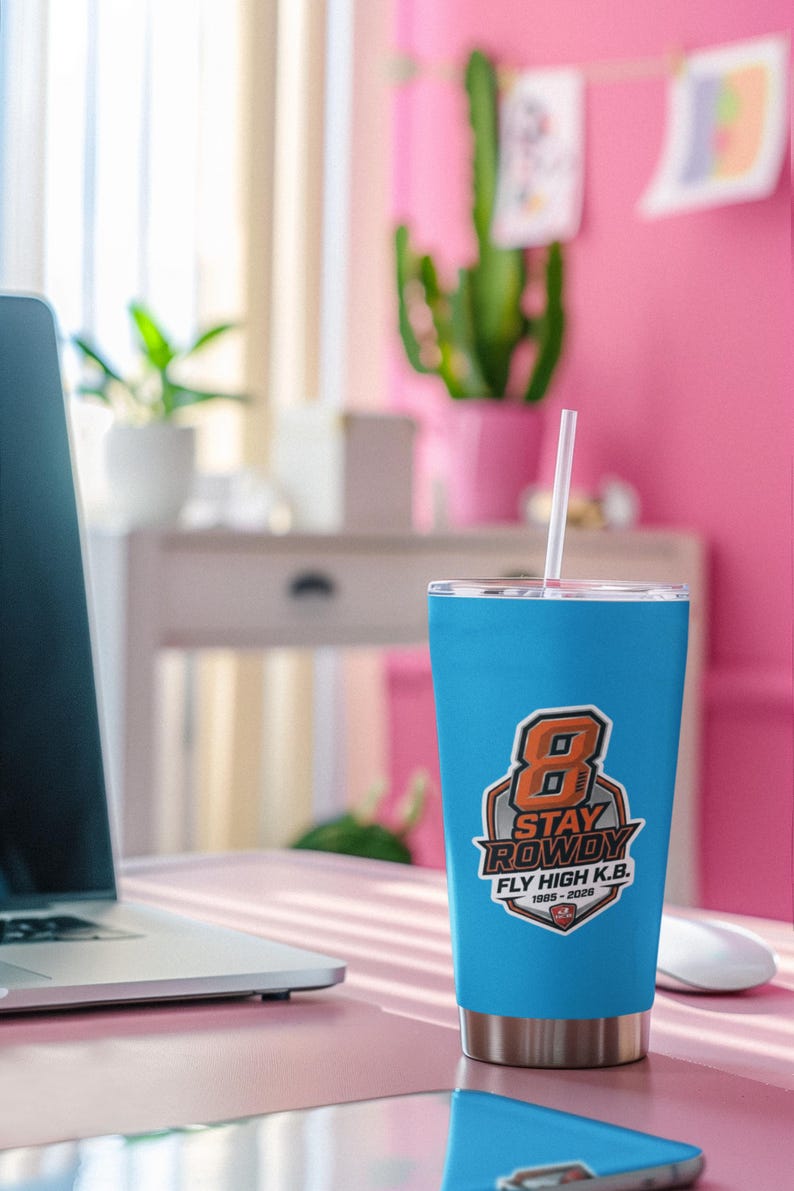 May include: A bright blue stainless steel tumbler with a clear lid and a white straw. The front features a graphic with a large orange number 8, the text STAY ROWDY, FLY HIGH K.B., and the years 1985-2026 inside a shield-shaped emblem.