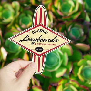 May include: A yellow diamond-shaped sticker with the text "Classic Longboards Custom Designs Est. 1954" and a red and white striped surfboard graphic.
