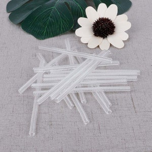 May include: A pile of clear, flexible, plastic drinking straws with a ribbed texture.