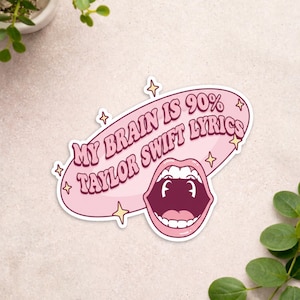 May include: A pink sticker with the text "MY BRAIN IS 90% TAYLOR SWIFT LYRICS" in a retro font. The sticker features an open mouth graphic and star accents.