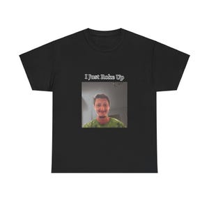 May include: Black t-shirt with the text "I Just Woke Up" and a photo of a man in a green shirt.